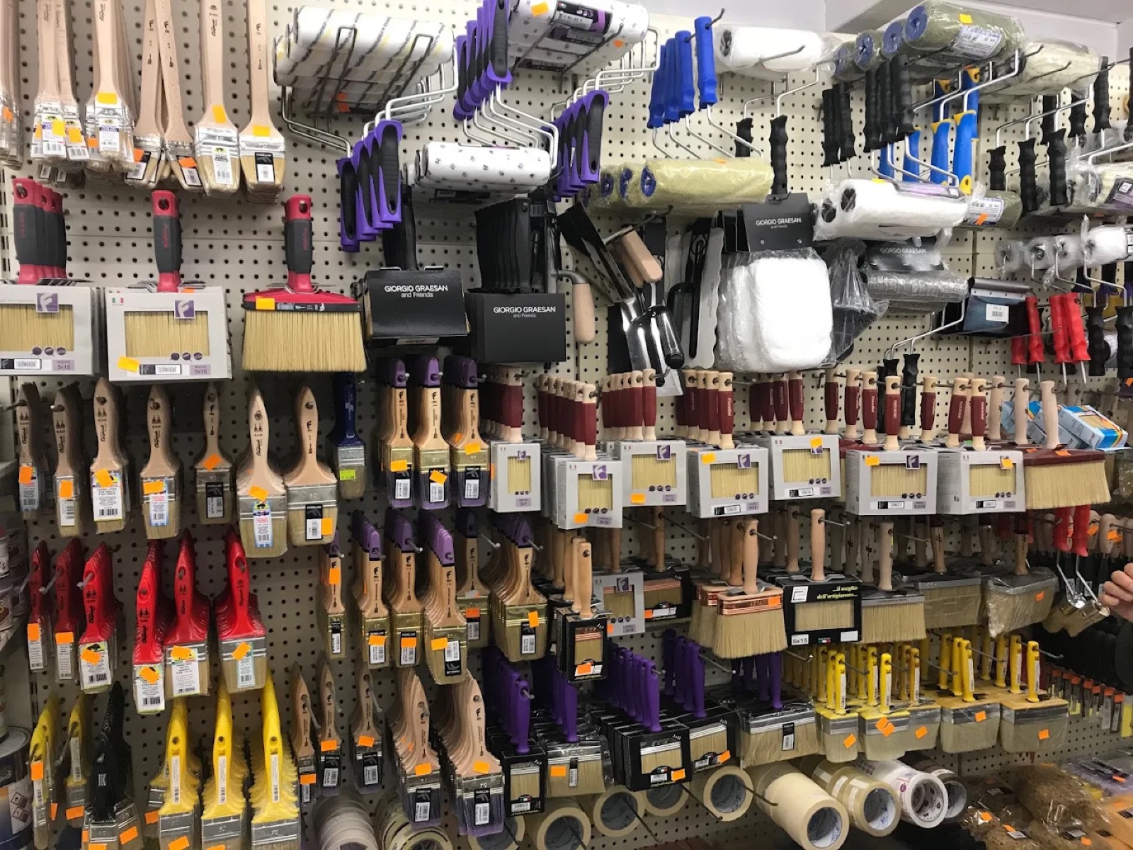 Parete con pennelli, rulli e accessori per pittura